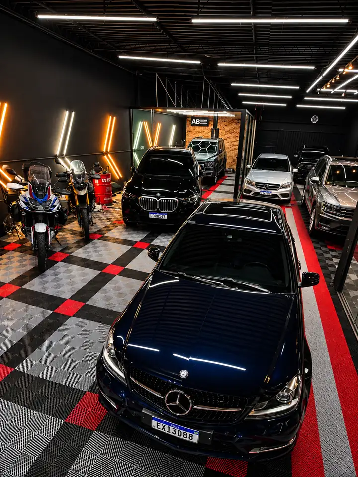 Carros e motos no studio Andrey Bim, com iluminação especial e piso preto e vermelho